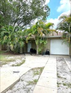 a house with palm trees and a garage at Hostal Sky Crest in Clearwater