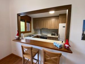 eine Küche mit einer Theke mit 2 Stühlen und einem Kühlschrank in der Unterkunft Vitivola Els Esquiadors de Llorts in Llorts