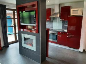 a kitchen with a fireplace with a tv above it at Ferienwohnung am Niederrhein in Kevelaer