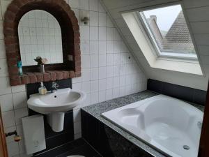 a bathroom with a sink and a bath tub at Ferienwohnung am Niederrhein in Kevelaer +5 photos