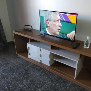 una TV a schermo piatto posizionata sopra un centro di intrattenimento di Moderno y amplio apartamento con vista fantástica en pleno centro a Ciudad del Este