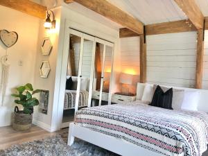 a bedroom with a white bed and a mirror at Maison Solange-Red Barn Farmhouse Style- Moonridge in Big Bear Lake