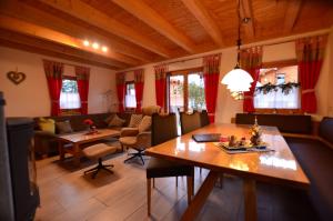 a living room with a table and a couch at Feriendorf Via Claudia Haus 82 Alpensee in Lechbruck