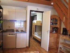 uma cozinha com armários brancos e uma cama num quarto em Appartement Châtel, 2 pièces, 6 personnes - FR-1-200-211 em Châtel