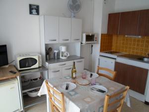 una pequeña cocina con mesa y microondas en Studio Balaruc-les-Bains, 1 pièce, 4 personnes - FR-1-503-25, en Balaruc-les-Bains
