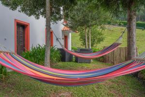 a hammock in a yard next to a house at Cantinho Rural in Camacha