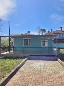 une maison bleue avec une clôture devant elle dans l'établissement in the village, with a garden, one floor. Detached, à Silivri