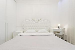 ein weißes Schlafzimmer mit einem weißen Bett und einem Schreibtisch in der Unterkunft 10353 Residential complex Central Park cozy apartment in Kiew