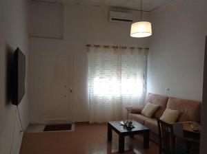 a living room with a couch and a table and a window at El Rincón de Paula in Baena