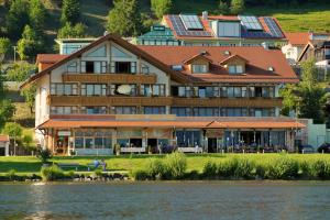 une grande maison sur la rive d'un lac dans l'établissement Residenz Hopfensee, à Füssen