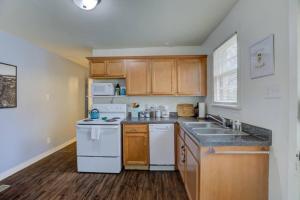 a kitchen with white appliances and wooden cabinets at Midtown Cottage Walk to Overton Square in Memphis