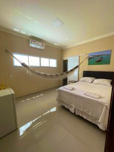 een slaapkamer met een bed en een hangmat. bij Floripa Flat in Areia Branca