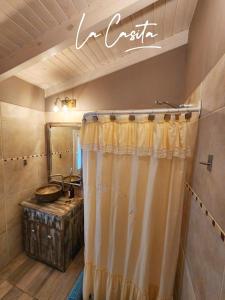 a bathroom with a shower curtain and a sink at La Casita in Junín de los Andes