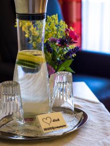 a table with a vase and a plate with a plate with a bottle at Pension Kilger in Mauth