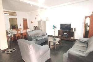 sala de estar con sofás blancos y TV en RESIDENCIA TUKITUKI CASA HERMOSA IQUITOS AMAZONIA en Iquitos