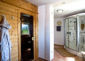 ein Bad mit einer Glasdusche und einer Tür in der Unterkunft Pension Kilger in Mauth