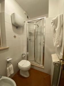 a bathroom with a toilet and a glass shower at Ospitalità Perusia in Tuoro sul Trasimeno