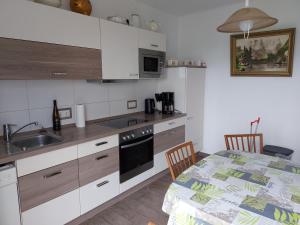 a kitchen with white cabinets and a table with a sink at Ferienwohnung-Havelsee in Hohenferchesar