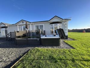 a house with a hot tub in the yard at Stewarts Resort Lodge 4 in St. Andrews