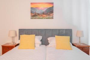 Cantinho Rural في Camacha: غرفة نوم بسرير مع مصباحين ولوحة