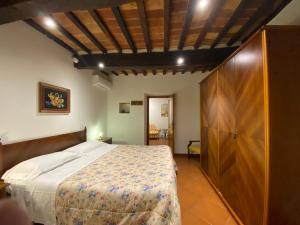 una camera con un grande letto e un armadio in legno di Ospitalità Perusia a Tuoro sul Trasimeno