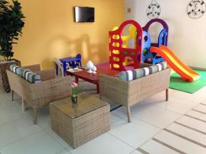 Praia dos carneiros flat hotel في تامانداري: غرفة لعب مع طاولة وكراسي وملعب