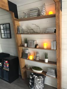 Maison Solange-Red Barn Farmhouse Style- Moonridge في بيغ بير لاكي: غرفة مع رفوف خشبية مع الشموع والنباتات