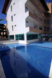 a large swimming pool in front of a building at Praia dos carneiros flat hotel in Tamandaré