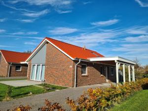 a brick house with an orange roof at House Silence in Sehestedt