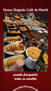 um buffet com muitos tipos diferentes de alimentos em pratos em 103 Hotel & Flats em Palmas
