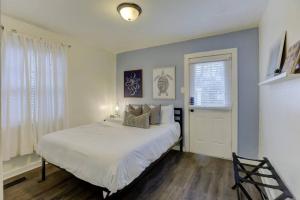 een slaapkamer met een groot wit bed en een raam bij Gated Midtown Cottage with Perfect Location in Memphis