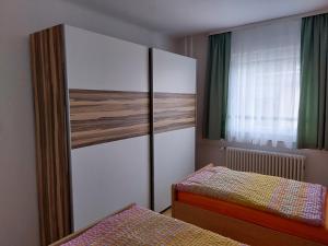 a bedroom with two beds and a large wardrobe at Ferienwohnung-Havelsee in Hohenferchesar