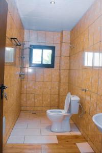 a bathroom with a toilet and a sink at Résidence Deluxe in Yaoundé