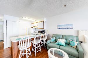 Seaward Villas 301 في آوشين سيتي: مطبخ وغرفة معيشة مع أريكة وطاولة