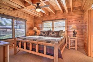 1 dormitorio con 1 cama en una cabaña de madera en Upscale Sevierville Retreat with Deck and Hot Tub!, en Sevierville