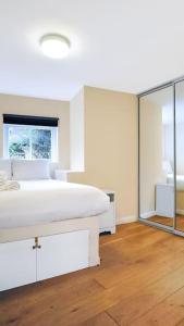 um quarto branco com uma cama grande e um espelho em Lovely 2 - bedroom London Bridge apartment em Londres