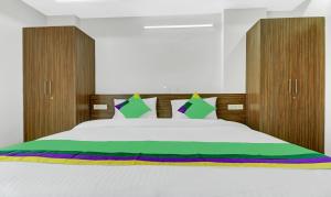 a bedroom with a large white bed with wooden headboards at Treebo Trend Raga in Visakhapatnam