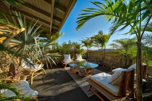 a patio with chairs and a table and palm trees at The Montauk Beach House in Montauk