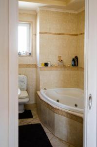 La salle de bains est pourvue d'une baignoire et de toilettes. dans l'établissement AIGIO PARK APARTMENT, à Aigio