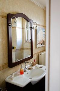 een badkamer met een wastafel en een spiegel bij AIGIO PARK APARTMENT in Aigio