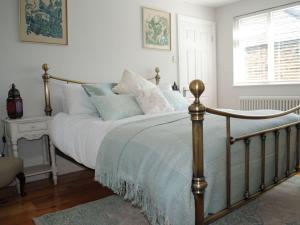 a bedroom with a bed with white and blue pillows at Laburnum Cottage in Alnwick