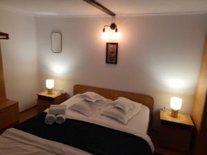 a bedroom with a bed with two lights on it at Pensiunea Poiana Soarelui in Ciungetu