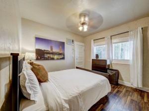 1 dormitorio con 1 cama blanca grande y ventanas en Perfect Location Walking Distance to Everything, en Sacramento