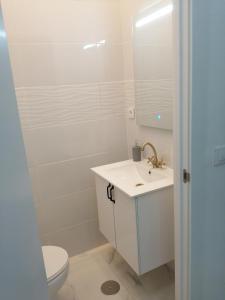 Un baño con inodoro, lavabo y ducha. en HELLO HOME FERIA, en Madrid