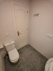 a bathroom with a white toilet and a door at Luxury Apartments Mascarat in Altea