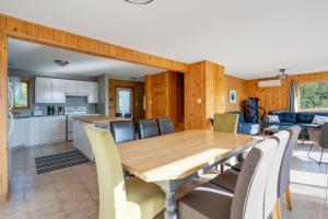 a dining room and kitchen with a wooden table and chairs at MontFJORD - Chalets, SPA et vue - ChantaFJORD #1 in Sacré-Coeur-Saguenay