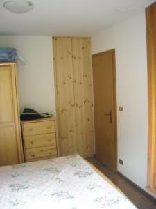 a bedroom with a bed and a wooden closet at Casa Erica - Carano in Carano