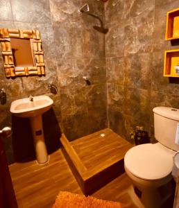 a bathroom with a toilet and a sink at Hosteria El Edén de Maria Isabel in Santa Rosa