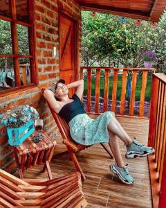 une femme assise sur une chaise sur une terrasse couverte dans l'établissement Hosteria El Edén de Maria Isabel, à Santa Rosa