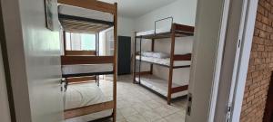 um quarto com 2 beliches e uma porta em Hostel Praia 102 em Ubatuba